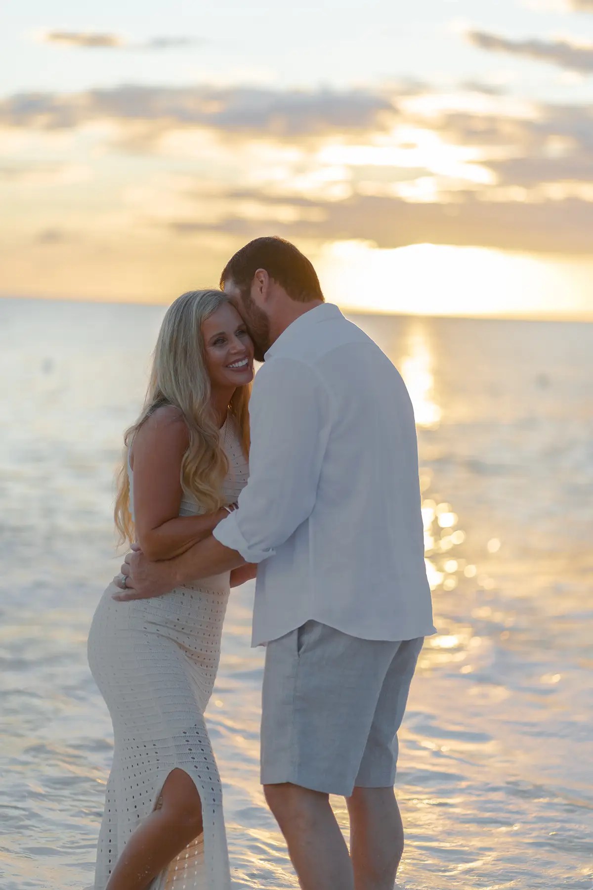 Couple embracing at sunset on Antigua Keyonna Beach.